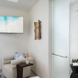 Your spacious suite features a luxurious walk-in shower with rainfall head and premium amenities, plus a cozy seating nook for ultimate relaxation.