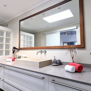 Pamper yourself in this sleek bathroom with modern stone counters, elegant mirror, and thoughtfully placed amenities for your comfort.