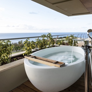 Soak in your private outdoor tub while gazing at endless ocean views from your balcony sanctuary.