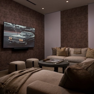 Sink into plush seating for your ultimate movie night in this cozy theater room with surround sound.