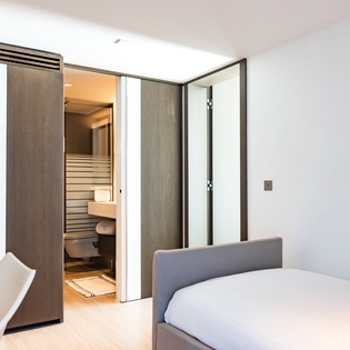 Your modern suite features a private sauna with sleek wood accents, perfect for unwinding after exploring the city.