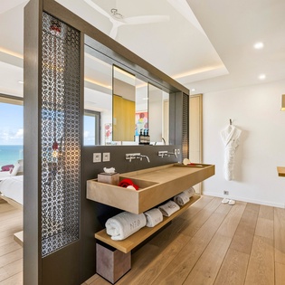 Unwind in your luxurious bathroom with stunning sea views, featuring elegant stone vanity and premium amenities for your perfect getaway.