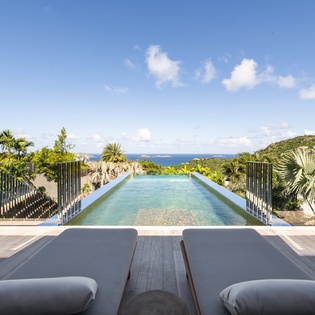 Stunning infinity pool with panoramic ocean views and tropical surroundings create the perfect paradise escape.