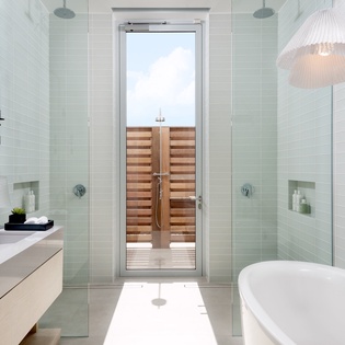 Step into your private spa sanctuary with a soaking tub, rain shower, and outdoor shower access.