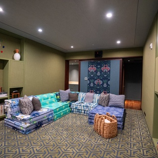Cozy up in your stylish living room featuring vibrant floor cushions and a warm fireplace for memorable evenings.