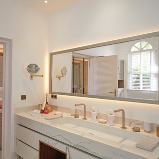 Your elegant ensuite bathroom features dual vanities with marble countertops, perfect for your morning routine together.