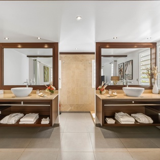 Unwind in your luxurious double vanity bathroom with spa-like vessel sinks, warm wood finishes, and fluffy towels awaiting your arrival.