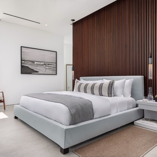 Drift off in your serene bedroom sanctuary, where crisp linens meet warm wood tones and natural light streams through floor-to-ceiling windows.