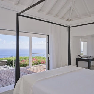 Wake up to stunning sea views from your elegant four-poster bed, with tropical blooms and azure waters creating a dreamy backdrop.