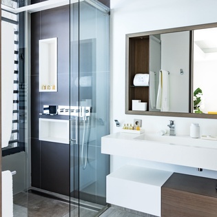 Indulge in your private spa-like bathroom with sleek marble counters, rainfall shower, and premium amenities for ultimate relaxation.