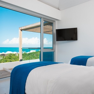 Wake up to breathtaking ocean views from your bed, with floor-to-ceiling windows framing endless turquoise waters and white sand beaches.