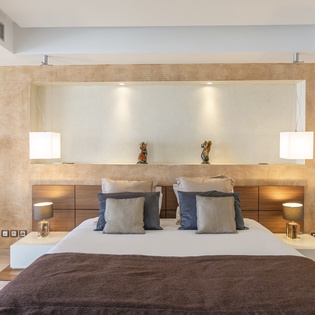 Your tranquil sanctuary awaits with crisp linens, textured accent walls, and soft lighting. The plush bed and elegant design invite you to unwind after a day of exploration.