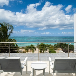 Stunning oceanfront balcony with pristine turquoise waters just steps away. Relax on comfortable loungers while tropical breezes refresh your soul.