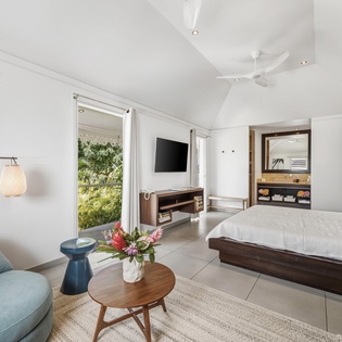 Relax in your stylish suite with tropical garden views, plush seating, modern amenities, and a peaceful atmosphere perfect for unwinding.