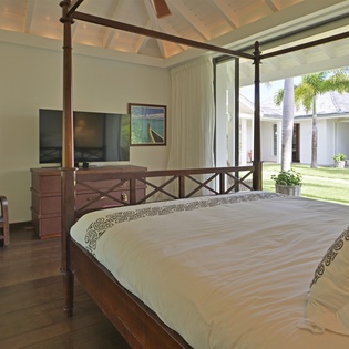 Wake up in this elegant four-poster bed with tropical garden views streaming through your floor-to-ceiling windows.