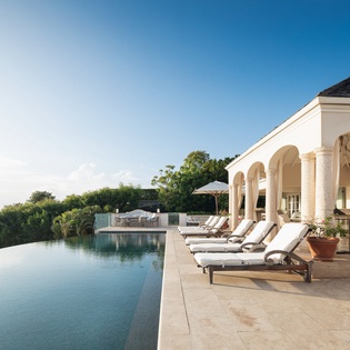 This elegant property features a stunning infinity pool and covered terrace surrounded by lush tropical greenery, offering an exclusive island retreat for ultimate relaxation.