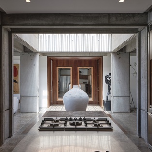 Your stunning kitchen flows seamlessly into the courtyard, where natural light streams through the glass ceiling onto elegant concrete and warm wood.