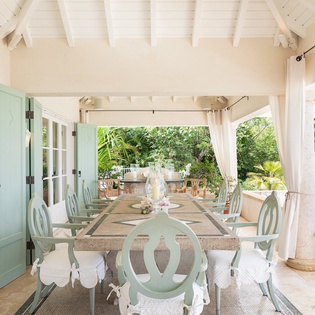 Step into your private covered dining terrace, where soft coastal breezes and lush tropical gardens create an enchanting setting for memorable meals under the vaulted beam ceiling.