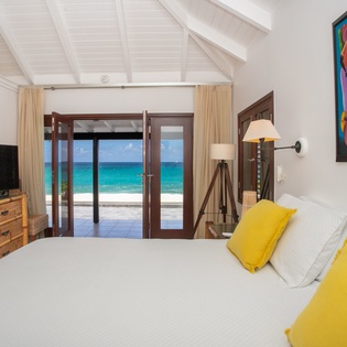 Wake up to vibrant art and step through your doors to soft sand and turquoise waves. This bright bedroom brings the ocean to your bedside with crisp linens and tropical hues.