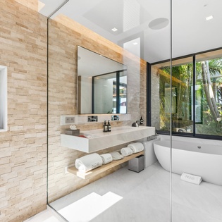 Unwind in your spa-like sanctuary with a soaking tub, rainfall shower, and tropical garden views through floor-to-ceiling windows.