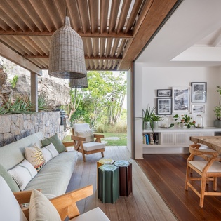 Sink into the plush sofa and let the natural light and garden views wash over you in this seamlessly blended indoor-outdoor living space.