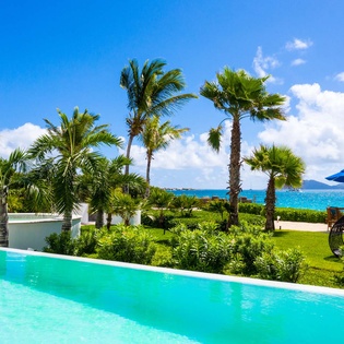 This beachfront oasis features a sparkling infinity pool framed by swaying palms, manicured lawns, and stunning turquoise ocean vistas—your private slice of tropical paradise awaits.