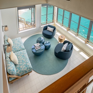 Your waterfront living room offers breathtaking ocean views through floor-to-ceiling windows, where you'll unwind on plush seating while watching the waves.