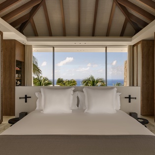 Wake up to stunning ocean views from your luxurious bed, where natural textures and modern comfort create your perfect tropical retreat.