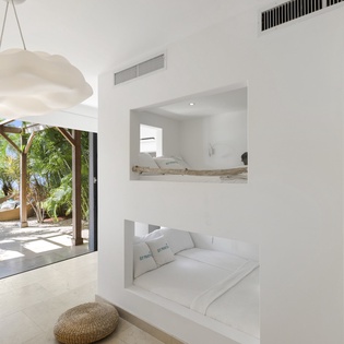 Drift off in your private sleeping nooks with tropical garden views just beyond the glass doors.