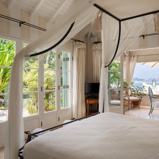 Drift off in your elegant four-poster bed with ocean breezes and tropical views on both sides—paradise never felt so peaceful.