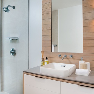 Step into your spa-like bathroom with rainfall shower, modern vanity, and warm wood accents that create the perfect morning ritual.