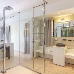 Step into your luxurious ensuite with a stunning walk-in rain shower, sleek double vanities, and elegant glass shelving—everything designed for your ultimate comfort and relaxation.