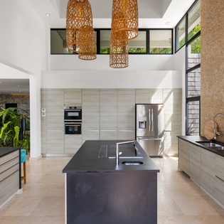 Your gourmet kitchen awaits with sleek appliances, spacious island, and warm bamboo lighting creating the perfect culinary sanctuary.