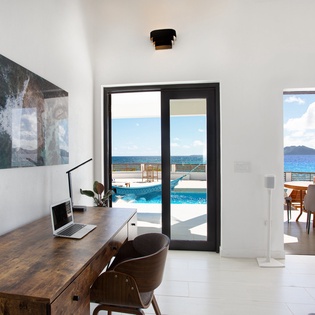 Imagine working from this bright, airy space where ocean breezes meet modern comfort. Your private terrace and pool open seamlessly to stunning blue water views—perfect for blending work with relaxation.
