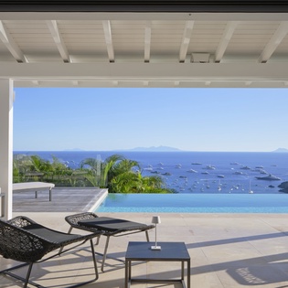 Luxurious oceanfront terrace with panoramic Caribbean views. Your private infinity pool creates seamless blues stretching to distant sailboats and islands.