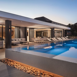 Stunning modern villa featuring infinity pool with dramatic evening lighting and seamless indoor-outdoor living spaces.