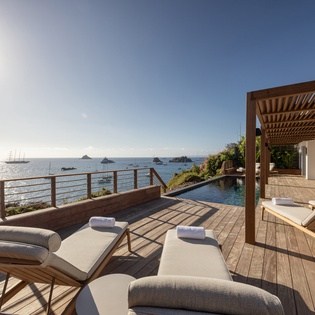 Unwind on your private oceanfront terrace with plush loungers and endless sea views. Modern comfort meets serene coastal luxury.