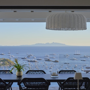 Savor meals at your dining table while gazing at the stunning harbor dotted with sailboats and distant mountain peaks.