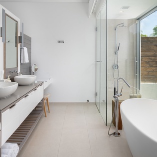 Indulge in your private spa sanctuary with dual sinks, rainfall shower, and soaking tub, all bathed in natural light.
