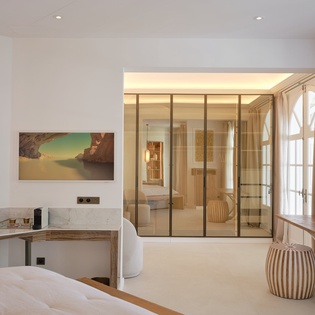 Your elegant suite features a luxurious marble workspace and stunning glass-walled bathroom, creating the perfect blend of productivity and relaxation.