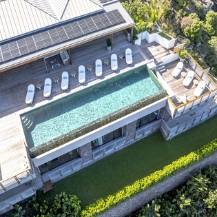 Stunning modern villa with infinity pool surrounded by lush tropical landscape, featuring elegant outdoor lounging areas and contemporary architecture.