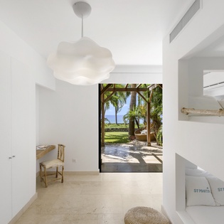 Step into your serene bedroom with built-in bunk beds and stunning tropical views through floor-to-ceiling windows.