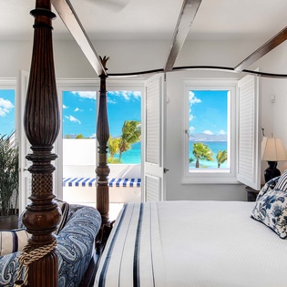 Wake up to breathtaking ocean views framed by elegant shutters. Your private sanctuary features a handcrafted four-poster bed, coastal-inspired décor, and direct access to sun-drenched terraces overlooking turquoise waters.