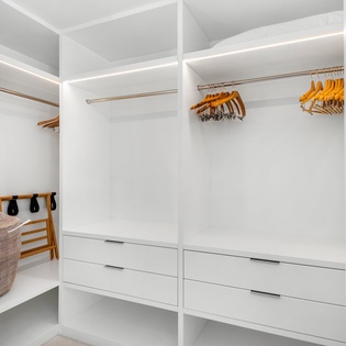 Your spacious walk-in closet offers elegant organization with built-in drawers, hanging rods, and soft LED lighting for all your belongings.
