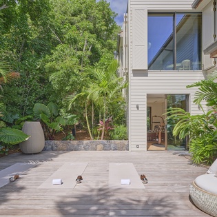 A tranquil outdoor yoga deck nestled among lush tropical greenery offers a serene escape for morning stretches and peaceful meditation.