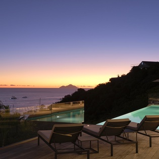 Stunning sunset views over the ocean with infinity pool and loungers for your perfect evening unwind.