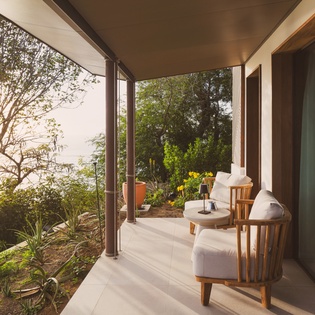 Unwind in your private covered terrace, where comfortable seating meets tropical garden views and gentle ocean breezes.