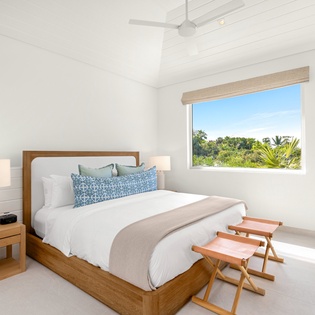 Wake up to lush tropical views from your bright, airy bedroom with crisp linens and coastal-inspired decor.