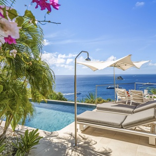 Relax on your private pool deck with stunning ocean views, tropical blooms, and luxurious loungers perfectly positioned for ultimate comfort.