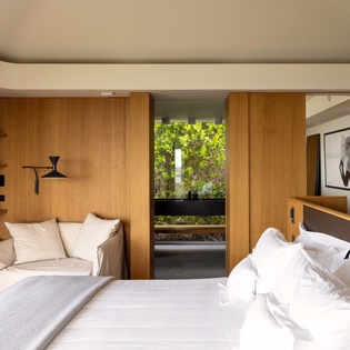 Your modern sanctuary features warm wood tones, crisp linens, and a peaceful reading nook with garden glimpses.